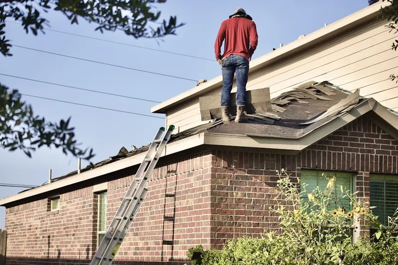 Professional roofer working on a residential roof in Armel